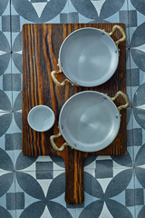 Wooden board with empty metal pans and cup