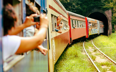Pessoas felizes passeando de trem, tirando fotografias e entrando em um túnel. Turistas viajando em ferrovia.