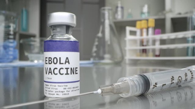 Ebola vaccine with syringe placed next to it slowly moving past bottle in medial lab.