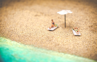 Fototapeta na wymiar summer background sunbather couple in deserted beach sunbathing with copy space