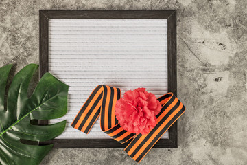 Message plate with empty place for text, red carnation, symbol of May 9th St. George’s ribbon and...
