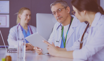 Serious medical team using a laptop in a bright office