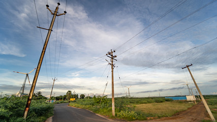 high voltage pillar power supply across a rural landscape during sunset