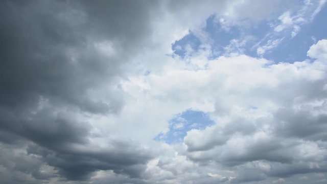 Beautiful video timelapse of amazing cloudy sky with fluffy sunny white clouds and dark grey heavy rainy clouds isolated against blue sky background.