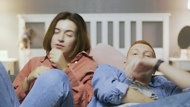 Couple watching attentively football match on tv. feeling anxious supporting their team and beeing disappointed because of loss. Sports fans sad of team losing game.
