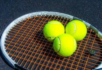 Tennis balls lie on a tennis racket