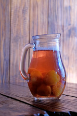 Georgian national cuisine. Georgian, homemade drink, compote in a jug. Drink on a wooden table.