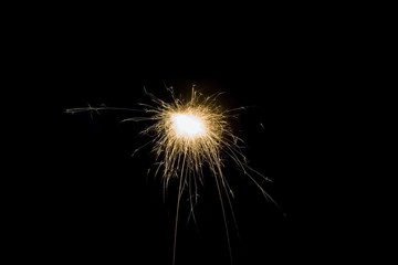 firework sparkles with light trail with bright orange light with black isolated background