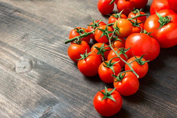 red tomatoes of different sizes and varieties on a wooden background. top view and copyspace. salad recipe ingredients for pasta. seasonal vegetables for healthy diet. selective focus