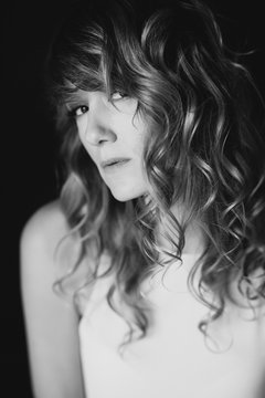 Portrait of a 36 year old woman with curly hair and brown slanting eyes. Soft selective focus. Black and white art photo.