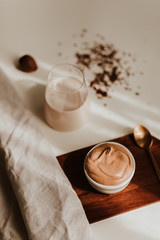 Flat lay of coffee cream and milk chocolate on a white background – minimalist breakfast concept in natural light