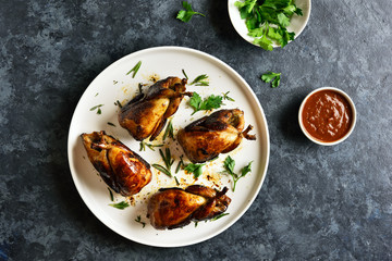 Roasted quails on white plate