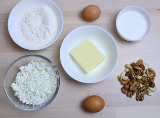 Fototapeta na wymiar view from above. ingredients for the preparation of cottage cheese pie, cake in a glass bowl, stand on a light surface of the table. Cooking breakfast at home. Granular cottage cheese, butter, sugar