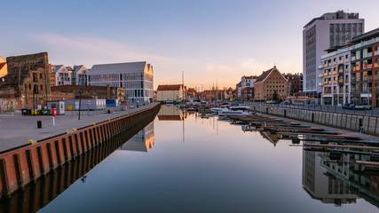 Fototapeta premium View of city Gdansk at sunrise. The promenade along the riverbank of Motlawa River and a marina.
