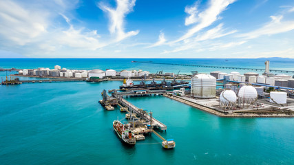 Aerial view oil treminal with storage tank farm, offshore oilrig, tanker and port, land oil rig,...