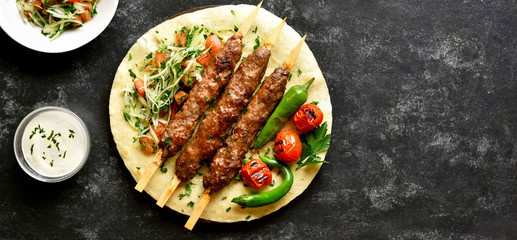 Adana Kebab with fresh vegetables on flatbread - obrazy, fototapety, plakaty