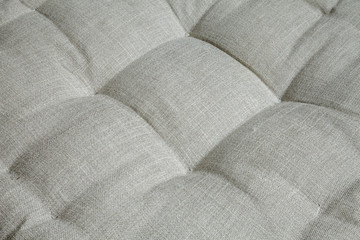 Gray upholstered furniture textile background. Soft, comfortable armchair seat close-up