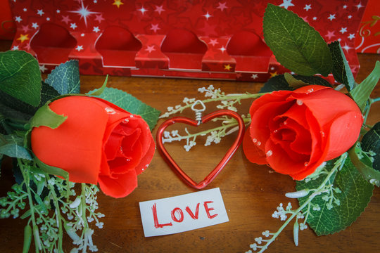 Close-up Of Love Text And Flowers On Table