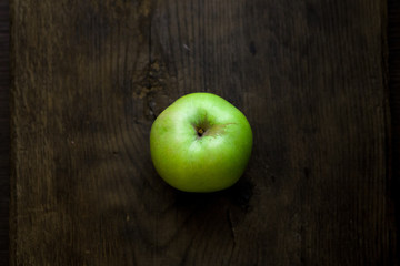 Green organic healthy apples in bowl on wooden board. Healthy food