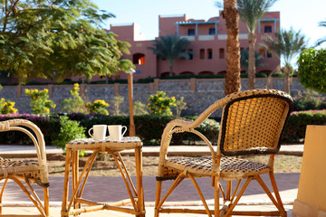 Fototapeta na wymiar table and rattan wicker seat chair. Wicker furniture rattan table two chairs near the window on balcony. empty chair at the hotel room. chair at the balcony
