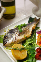 grilled dorado with lemon served with greens and salad bread and wine
