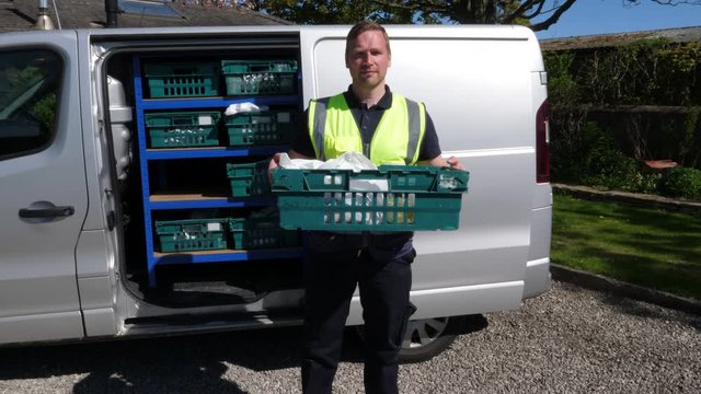 4K: Grocery delivery driver from Supermarket with a crate of food out of the van - Online order - Portrait. Wide Shot