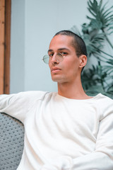 Obraz premium Exotic caucasian young man with a white jersey and round sunglasses