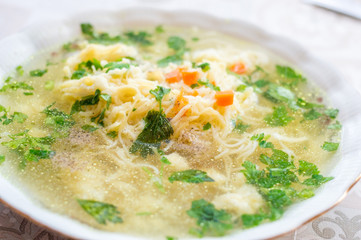 Plate of broth with noodles, carrot and and parsley. - obrazy, fototapety, plakaty