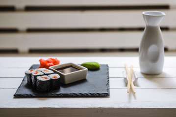 Japanese traditional rolls served in a sushi bar on white table. Sushi menu. Japanese food concept. Place for text