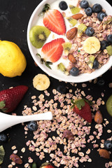 Granola. Granola with yogurt, on black wooden table