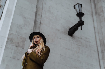 Blonde woman wearing the coat and hat looking to the side