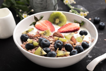 Granola. Granola with yogurt, on black wooden table