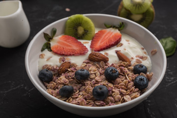 Granola. Granola with yogurt, on black wooden table