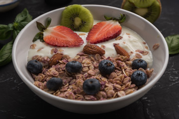 Granola. Granola with yogurt, on black wooden table