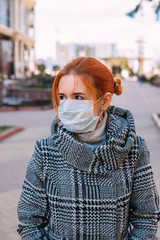 Street portrait of a young woman wearing protective medical mask during coronavirus pandemic - 342416976