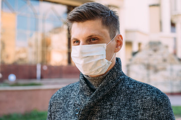 Portrait of guy wearing protection from coronavirus in city. Pandemic concept. - 342417177