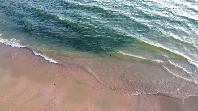 A sandy beach with breaking waves in Ao Nang town in Krabi province in Thailand. High quality footage areal view