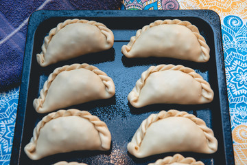 La tradicional empanada de carne argentina, sus ingredientes,  listas para ingresar al horno, como primer plano