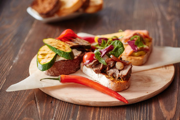 Assorted bruschetta with various toppings.Appetizing bruschetta.Variety of small sandwiches.Mix bruschetta