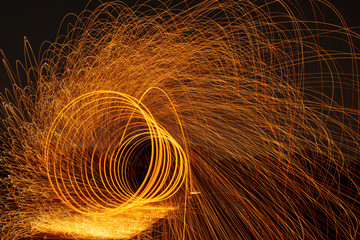 Image playing fireworks by rotating the wave shape of the lines, sparks to light. Amazing Fire Dance in the middle basin slope and beautiful reflection with copy space