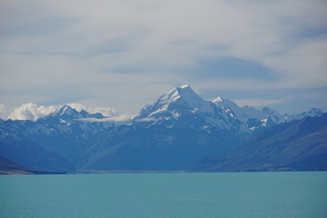 PUKAKI LAKE, NEW ZEALAND - MARCH 11, 2020: The range of Aoraki above the lake and thin clouds in the sky
