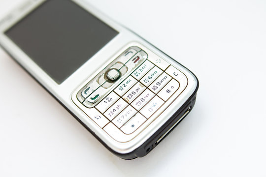 old push-button smartphone on a white background