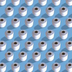 Many isolated toilet paper rolls, repeating pattern on blue background, square.