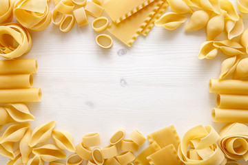 Set of various wheat pasta as a frame on a white background with copy space. Close up view 
