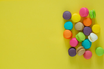 Sweet colorful macaroons on yellow background