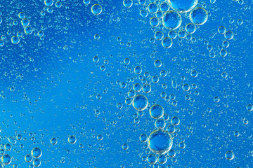 Macro Oxygen bubbles in water on a blue background, concept such as ecology and other your...