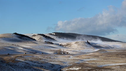 Drifting snow over the hills of Southern Alberta on a sunny winter day.