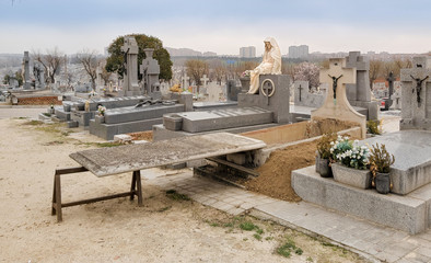 Tumba abierta esperando el cuerpo en el cementerio.