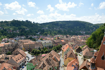 Fototapeta na wymiar Summer panoramic landscape of the old town. Old houses with orange brick roofs. Sighisoara, Mures County, Transylvania, Romania.