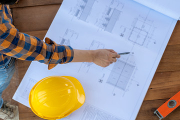 Engineer and architect discussing building plan at construction site,Group of builders having are...